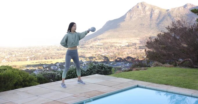 Lifestyle videos outdoor of people doing activities, Exercising outdoors, woman lifting kettlebell b