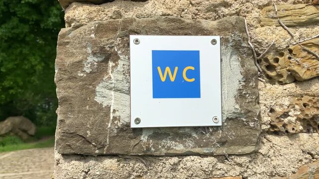 WC sign against a stone wall of an old street in Biarritz, France
