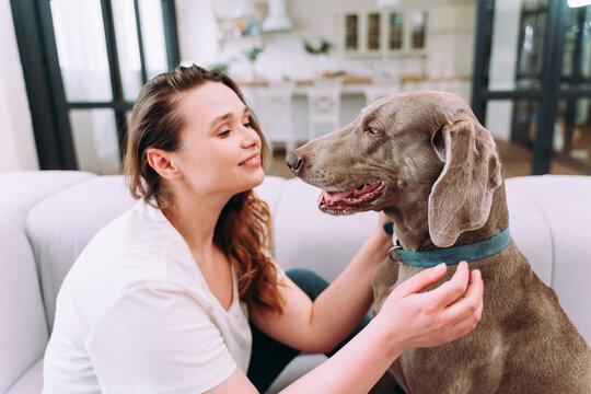 woman playing with her dog in the living room