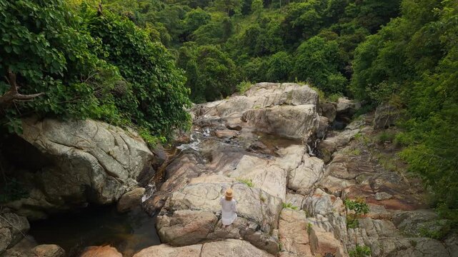 Woman Standing on Rocks at Na Muang Waterfall 2 in Koh Samui
