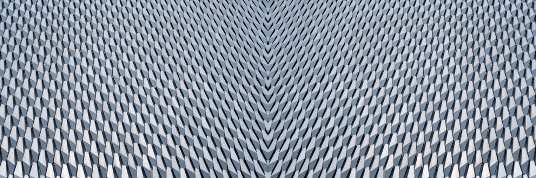 a modern building facade featuring a repeating geometric pattern
