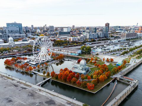 Aerial view of Montreal Old Port with La Grande Roue and Clock tower, autumn foliage, waterfront and downtown skyline