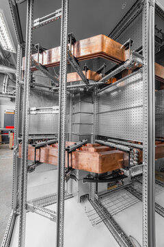 View of copper busbars installed inside an industrial electrical cabinet with metal framing and technical components in Latvia.