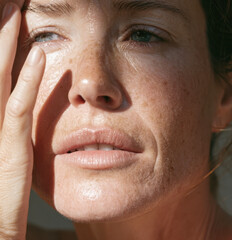 Fototapeta premium close up portrait of mature woman face with natural freckles wrinkles skin texture and sun light shading outdoor highlighting authentic aging beauty wellness aesthetic skincare routine care product