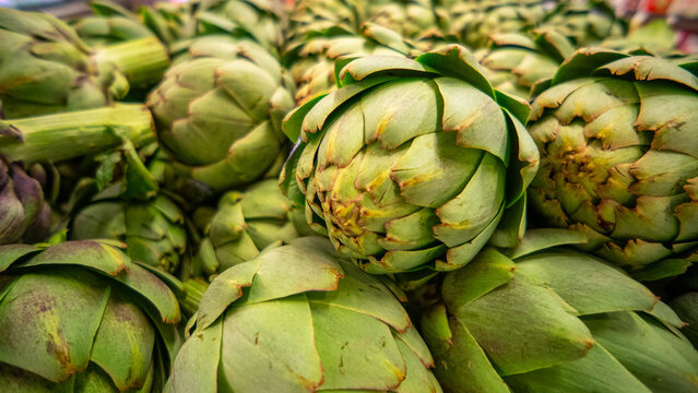 View of fresh green artichokes stacked in a market display in California City, California, United States.