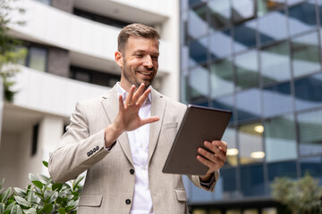Confident businessman using digital tablet in front of modern office building © Novak