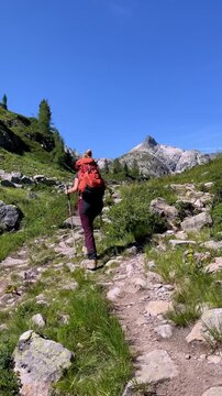 Woman Hiker Walking on Mountain Trail with Backpack under Blue Sky