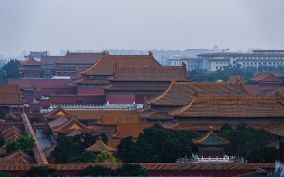 View of the historic Forbidden City with its iconic orange tiled roofs and traditional Chinese architecture set against an overcast sky in Beijing, Beijing, China.