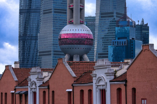 View of the Oriental Pearl Tower rising behind historic red brick buildings in the city center of Shanghai, Shanghai, China.