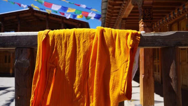Orange Monk Robe Drying in the Sun with Prayer Flags