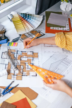 architect Eco retrofit planning with blueprints, material swatches and finish samples, sustainable renovation budget and healthy material selection concept for honest architectural design.