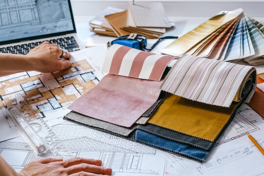 architect Eco retrofit planning with blueprints, material swatches and finish samples, sustainable renovation budget and healthy material selection concept for honest architectural design.