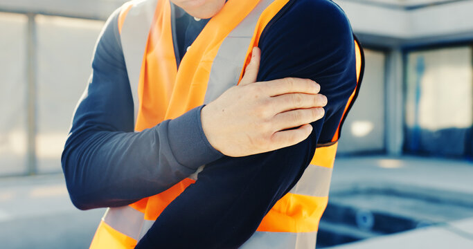 Construction, accident and man with shoulder pain, strain and injury for stress at building site. Engineering, hands and person with massage, hurt and muscle fatigue for burnout, sprain and mistake