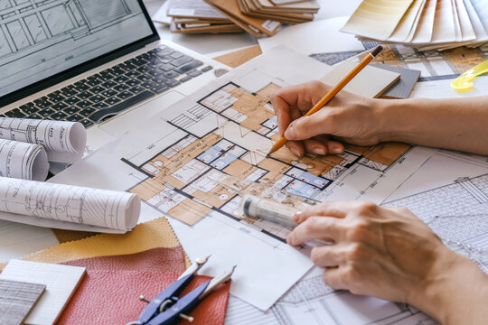 architect Eco retrofit planning with blueprints, material swatches and finish samples, sustainable renovation budget and healthy material selection concept for honest architectural design.