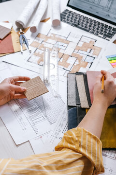 architect Eco retrofit planning with blueprints, material swatches and finish samples, sustainable renovation budget and healthy material selection concept for honest architectural design.