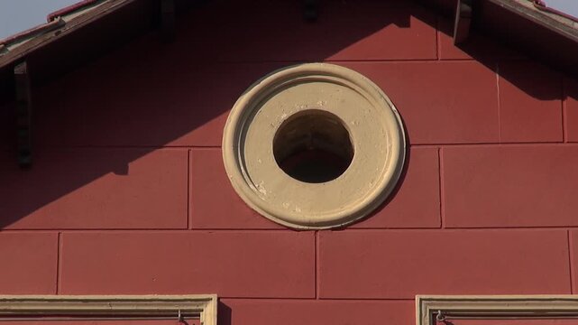 Building round window oculus bull's eye red attic roof sunlight