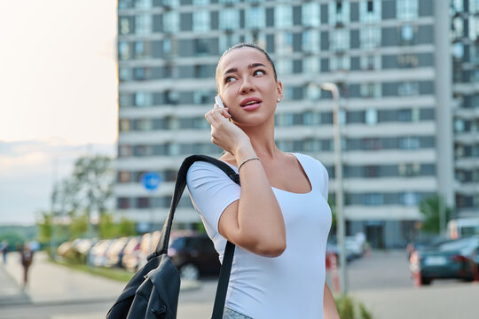Young woman talking on smartphone outdoor modern city portrait