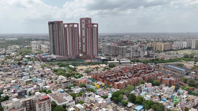 Cinematic aerial drone view of SPR City, Perambur, Chennai, showcasing prominent red-and-white high-rise residential towers surrounded by dense low-rise neighborhoods, modern apartment complexes