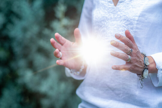 Mindfulness practice with glowing healing energy between open hands, spiritual wellness meditation