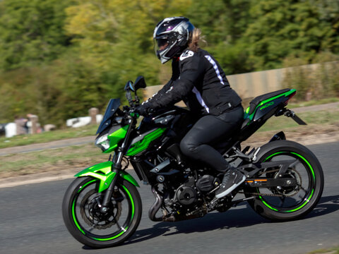 Milton Keynes; UK - Sept. 20th 2026: Woman riding a 2020 Kawasaki er 400 dkf motorcycle driving on a British road