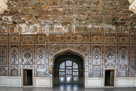 View of the intricate mirror work and marble inlay of the Sheesh Mahal at Lahore Fort, featuring detailed floral patterns and arched doorways in Lahore, Punjab, Pakistan.