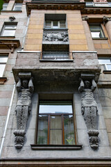 Art nouveau building facade with carved figures holding a balcony © Mariia