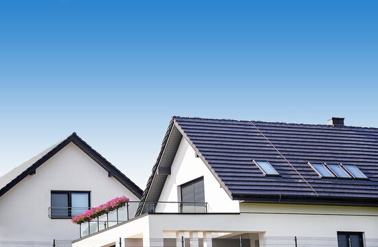 The dark blue top of modern new residential houses   Ceramic top roofs. Tiled covering of buildings. Blue sky cloude background. Copy space.
