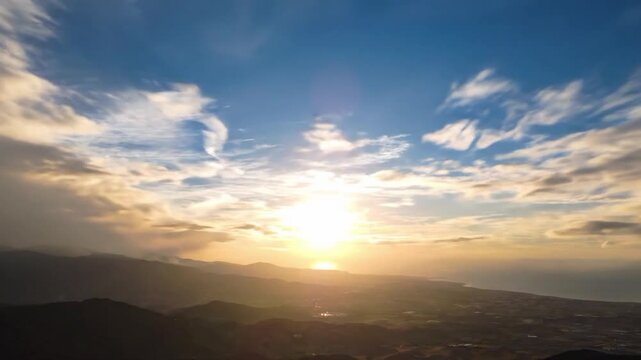 Time lapse of sun breaking through clouds over coastline in the morning