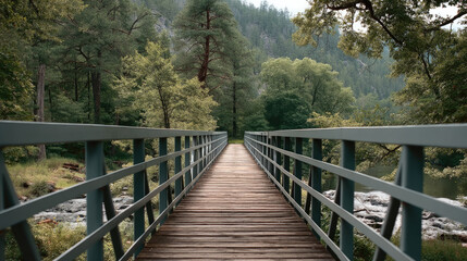 Fototapeta premium Centered view of wooden bridge with metal railings, surrounded by lush green forest and rocky riverbank, peaceful atmosphere