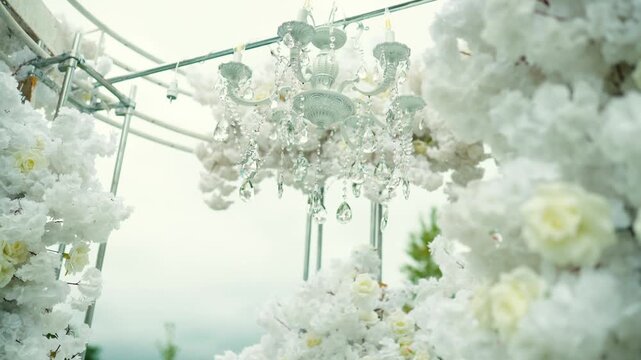 wedding arch of white rose flowers in the forest before the wedding ceremony of the bride and groom, festive romantic boho style decor