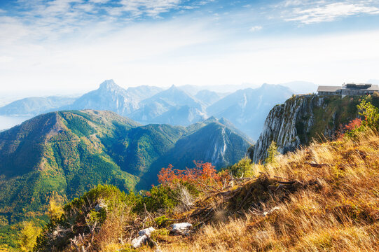 Autumn Alps mountains at foggy morning. Feuerkogel, Austria. Yellow grass and colorful trees in the mountains.