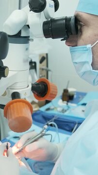 Professional ophthalmologist performing cataract removal and intraocular lens (IOL) implantation under a surgical microscope in an operating room.
