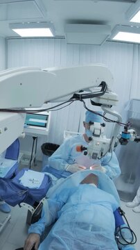 Professional ophthalmologist performing cataract removal and intraocular lens (IOL) implantation under a surgical microscope in an operating room.