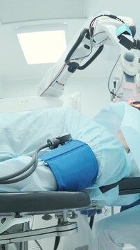 Professional ophthalmologist performing cataract removal and intraocular lens (IOL) implantation under a surgical microscope in an operating room.