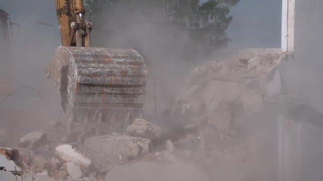 A crane demolishing a multi-story building in sunny weather.