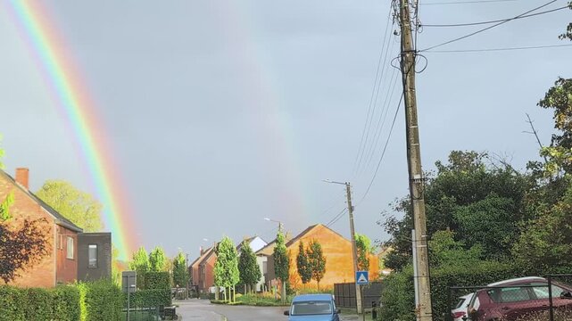 Bright rainbow over residential areas highlights city life and nature connection
