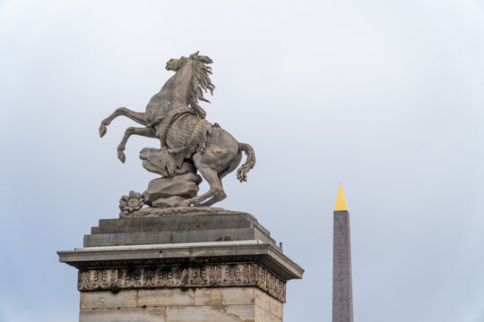 Statue of a rearing horse (Marly Horse) and the tip of the Luxor Obelisk at Place de la Concorde in Paris, France.