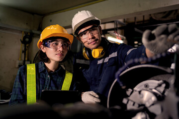 Fototapeta premium Two Industrial Technicians Collaborating to Inspect Heavy Machinery in Factory Workshop Representing Teamwork, Engineering Maintenance, Equipment Inspection and Workplace Safety