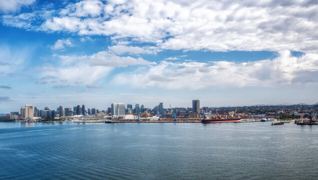 Panoramic view of San Diego skyline with clear blue sky and calm ocean waters.