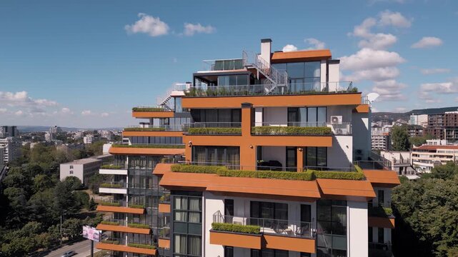 Modern luxury residential building penthouse with orange terraces and green plants