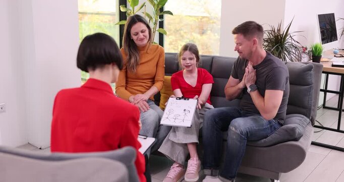 Girl shows colorful drawing to attentive therapist. Psychologist explains mom and dad feelings of kid through bright shapes and playful figures