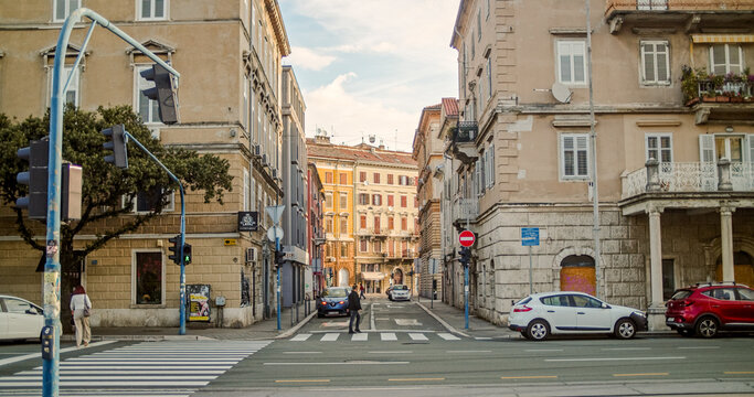 Rijeka, Primorje-Gorski Kotar, Croatia - 19 September 2026: View of a street intersection with historic buildings, traffic lights, a pedestrian crossing, and parked cars.
