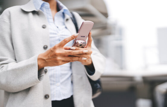 Close up Gen Z young asian businesswoman hand using pink flip phone youth culture digital device