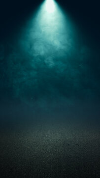 Dark abstract background with a bright teal spotlight shining down on a textured ground surface, filled with moody smoke and atmospheric haze, perfect for product display. Smoke background