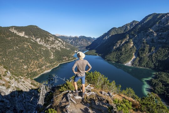Hiker looks into the distance, behind Sch&ouml;nj&ouml;chl, Plansee, Ammergau Alps, Reutte district, Tyrol, Austria