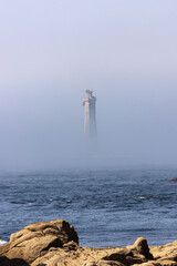 Le phare de Nividic apparaît au milieu d’une épaisse brume marine au large de la pointe de Pern, sur l’île d’Ouessant, créant une atmosphère mystérieuse en pleine mer d’Iroise © Tof - Photographie