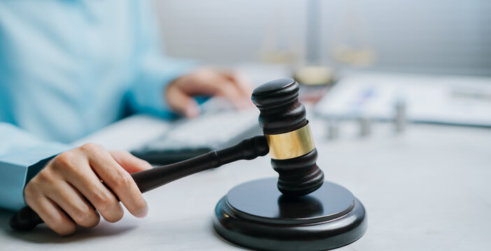 Judge holding gavel in courtroom feeling confident and professional while presiding over justice trial session with legal authority