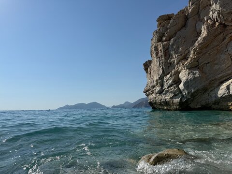 Rocky cliff by the blue sea on a sunny day