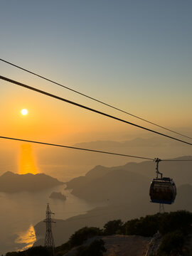 cable car riding above mountains during sunset