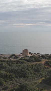 Vertical aerial view of Torre da Lapa, dramatic rocky cliffs, and the Atlantic coastline of the Algarve.